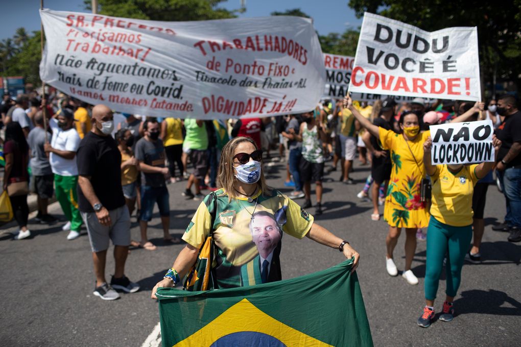 Supporters of Brazilian President Jair Bolsonaro protest the start of a 10-day period of increased restrictions, which includes Holy Week, to help curb the spread of COVID-19, on Copacabana beach in Rio de Janeiro, Brazil, Friday, March 26, 2021. (AP Photo/Silvia Izquierdo)