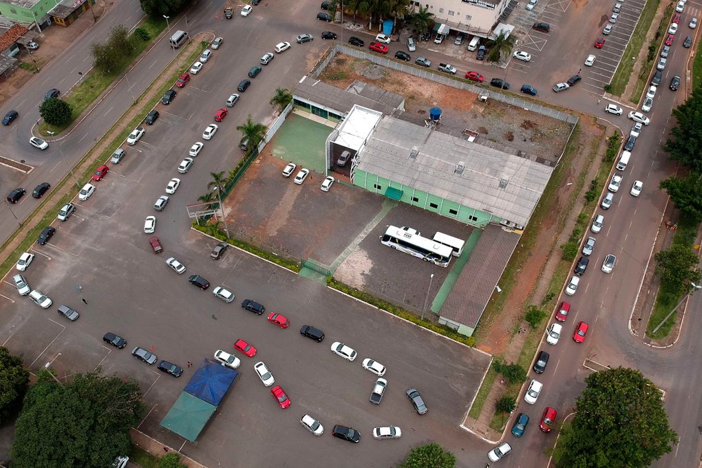 A line of vehicles curls around a COVID-19 vaccination point for priority elderly persons in the Ceilandia neighborhood, on the outskirts of Brasilia, Brazil, Monday, March 22, 2021. (AP Photo/Eraldo Peres)