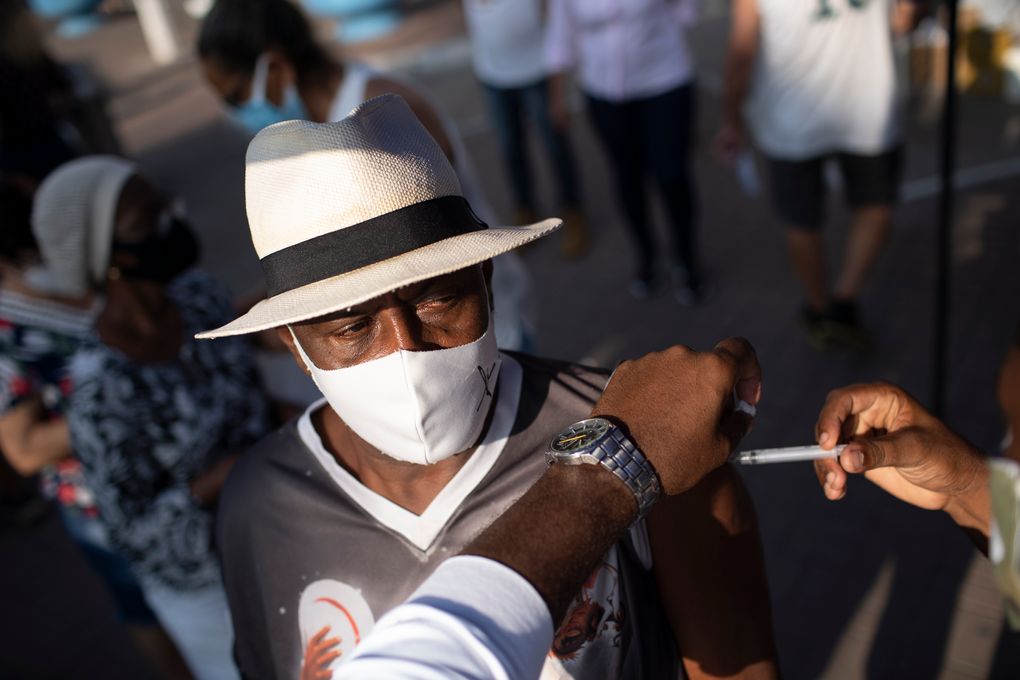 A man gets his dose of the Sinovac vaccine at a COVID-19 vaccination point for seniors in Duque de Caxias, Brazil, Wednesday, March 24, 2021. (AP Photo/Silvia Izquierdo)
