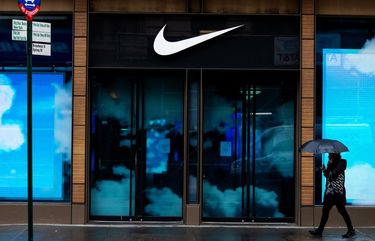 A pedestrian holding an umbrella passes in front of a closed Nike Inc. store in the SoHo neighborhood of New York, U.S., on Tuesday, March 17, 2020. In New York City, the virtual shutdown from the coronavirus pandemic is threatening to create massive holes in the budget as billions of dollars in tax revenue disappears. Photographer: Demetrius Freeman/Bloomberg