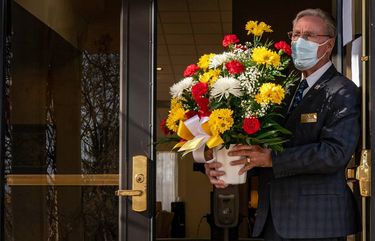 Ken Hammond, a funeral associate in Hagerstown, Md., holds flowers for the family of a man in his 50s who died of covid-19 in January 2021.