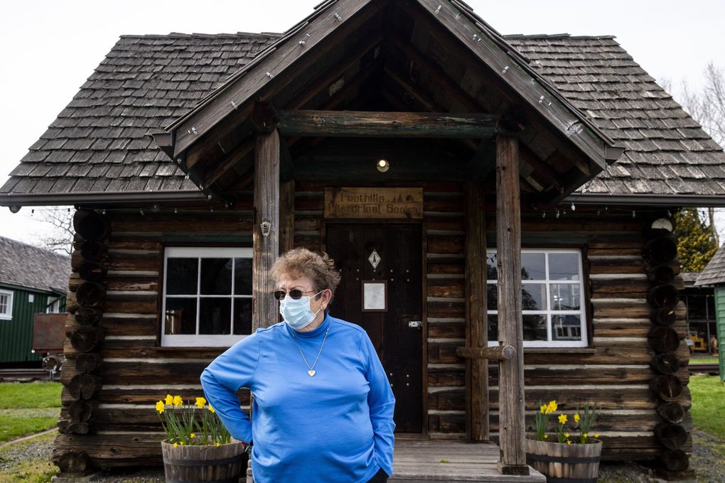 Martha Olsen, curator for the Foothills Historical Museum, in front of a log cabin that was built as Washington State Forestry Department guard station. It was located at Swede Point and moved when the White River eroded the riverbank out from under it. (Amanda Snyder / The Seattle Times)