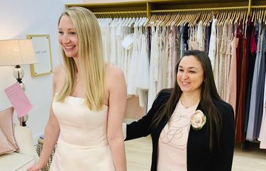 In this photo provided by Gilded Social, a bridal shop in Columbus, Ohio, owner Tanya Rutner Hartman helps customer Cristin Lee try on a gown at the shop on April 2, 2021. Although weddings and other big celebrations are going back on the calendar in the U.S., business owners who make those events happen expect a slow recovery from the impact of COVID-19. Hartman sees a shift in how couples feel about weddings, a change that can affect other businesses in the events industry as well. (Gilded Social via AP) NY455 NY455