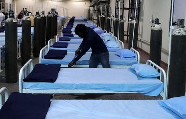 A worker cleans a newly set up C0VID- 19 hospital at Science Center in Mumbai, India, Tuesday April 13, 2021.. The teeming metropolis of Mumbai and other parts of Maharashtra, the Indian state worst hit by the pandemic, face stricter restrictions for 15 days starting Wednesday in an effort to stem the surge of coronavirus infections. (AP Photo/Rajanish Kakade) RKD101 RKD101