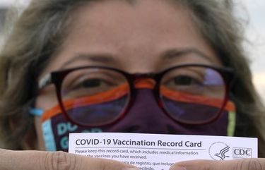 Alejandra poses with her vaccination card after getting her second Moderna COVID-19 shot Monday April 19, 2021, in Pasadena, Texas. Alejandra, a dentist who also lives in Monterrey, Mexico, said she decided to seek a vaccine in the U.S. shortly after losing her mother to COVID-19 in February. Many people with the means from Latin America are traveling thousands of miles to get the COVID-19 vaccine in the United States because supplies are limited in their own countries.  (AP Photo/David J. Phillip) NYAG903 NYAG903