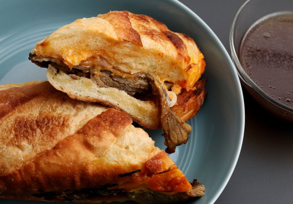 The Gooch from HoneyHole includes flame-grilled tri-tip, red onions, sharp cheddar and horseradish mayo on a demi baguette with a side of au jus. (Ken Lambert / The Seattle Times)