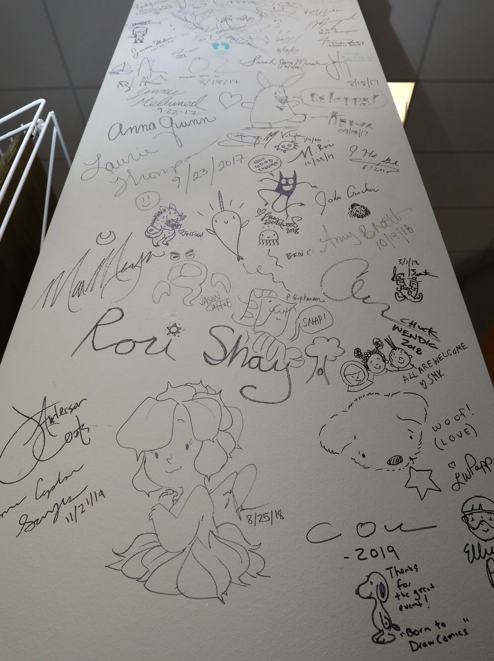 A focal point at Redmond’s Brick & Mortar Books is this pillar signed — or doodled upon — by authors who have visited the independent bookstore. (Ken Lambert / The Seattle Times)