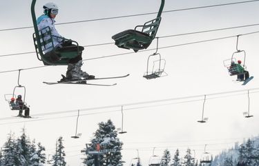 A skier rides the lift up a line at The Summit at Snoqualmie Pass on Christmas Day, Dec. 25, 2019.