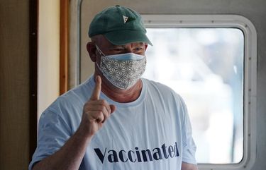 FILE-In this Friday, March 19, 2021, file photo, Jonathan Partin wears an appropriate tee-shirt as he celebrates receiving a COVID-19 vaccination aboard the Sunbeam in Northeast Harbor, Maine. The Sunbeam is a 74-foot vessel operated by the non-profit Maine Seacoast Mission. The mission has vaccinated hundreds of people who reside on Maine islands. (AP Photo/Robert F. Bukaty, file) MERB101 MERB101