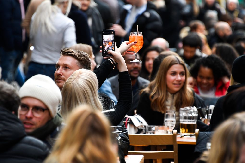 A woman takes a phone picture of her drink in Soho, London, on the day some of England’s coronavirus lockdown restrictions were eased by the British government in April. (AP Photo/Alberto Pezzali)