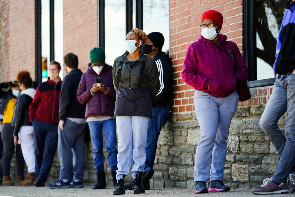 FILE – In this March 29, 2021, file photo, people wearing face masks as a precaution against the coronavirus wait in line to receive COVID-19 vaccines at a site in Philadelphia. Nearly half of new coronavirus infections nationwide are in just five states, including Pennsylvania — a situation that puts pressure on the federal government to consider changing how it distributes vaccines by sending more doses to hot spots. (AP Photo/Matt Rourke, File)