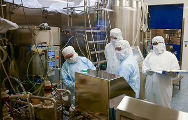 Manufacturing associates work on a COVID-19 vaccine in one of four flexible manufacturing suites at Emergent BioSolutions' Bayview facility in January. 248460R
