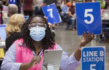 Taryn Walcott, a customer service representative, holds up a number to signal the next person waiting in line to come to her station so they can get a vaccine for COVID-19 at the Lumen Field Event Center, Wednesday, May 12, 2021.
Lumen Field Event Center is reportedly the largest civilian-run mass-vaccination site in the U.S.