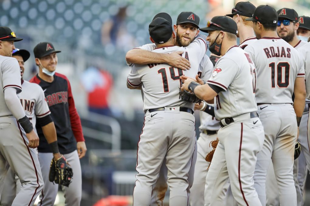Arizona Diamondbacks’ Asdrubal Cabrera embraces pitcher Madison Bumgarner after Bumgarner pitched a 7-inning no hitter against the Atlanta Braves, at the end of the second game of a double header, April 25, 2021, in Atlanta. Bumgarner struck out seven and had one batter reach base following an error. (Ben Margot / AP)