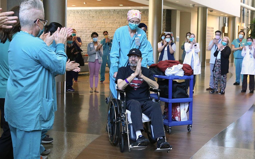 Hospital staffers applaud as Michael Flor leaves Swedish Issaquah on May 5, 2020. He made news for surviving a 62-day near death experience, at a price tag of $1.1 million. Now he is connecting with other survivors, helping people talk through their grief as society re-opens. (Ken Lambert / The Seattle Times)