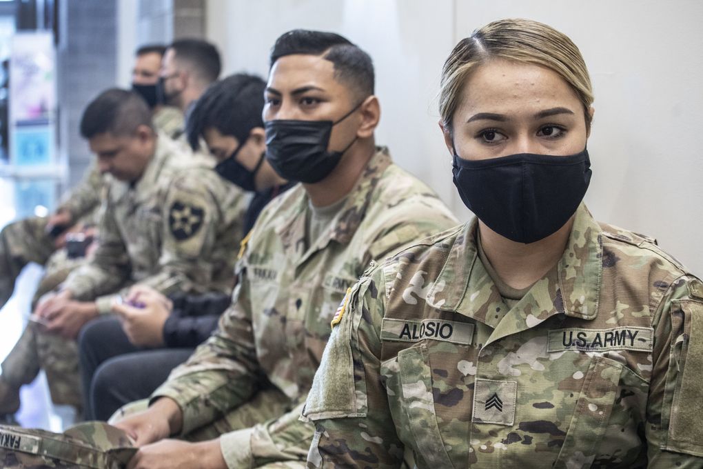 Sgt. Shanteo Alosio waits for 15 minutes after her COVID-19 vaccination on Thursday at the Joint Base Lewis-McChord in Pierce County. (Steve Ringman / The Seattle Times)