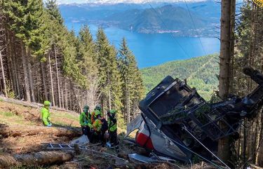 Rescuers work by the wreckage of a cable car after it collapsed near the summit of the Stresa-Mottarone line in the Piedmont region, northern Italy, Sunday, May 23, 2021. A mountaintop cable car plunged to the ground in northern Italy on Sunday, killing at least five people and sending at least three more to the hospital, authorities said. (Soccorso Alpino e Speleologico Piemontese via AP) MOT102 MOT102