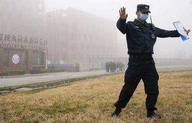 A security official moves journalists away from the Wuhan Institute of Virology after a World Health Organization team arrived for a field visit in Wuhan in China’s Hubei province on Wednesday, Feb. 3, 2021. The WHO team is investigating the origins of the coronavirus pandemic has visited two disease control centers in the province. (AP Photo/Ng Han Guan) XHG106