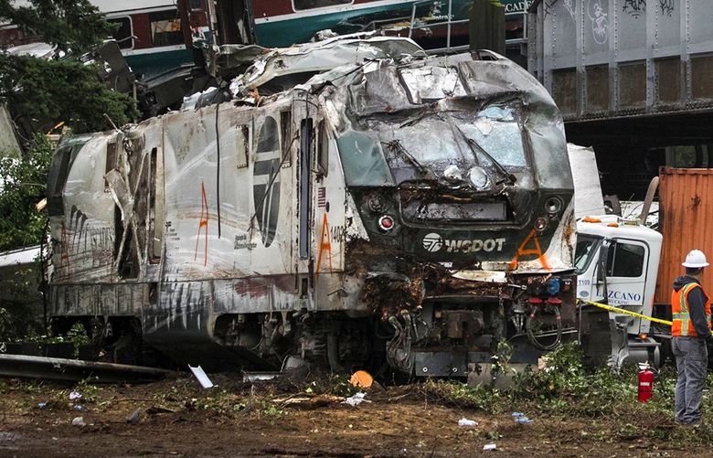 An Amtrak southbound train derails south of Mounts Road SW overpass (in background, at middle right) and partially rests in the I-5 southbound lane Monday, December 18, 2017. Looking northbound. (Ellen M. Banner / The Seattle Times)