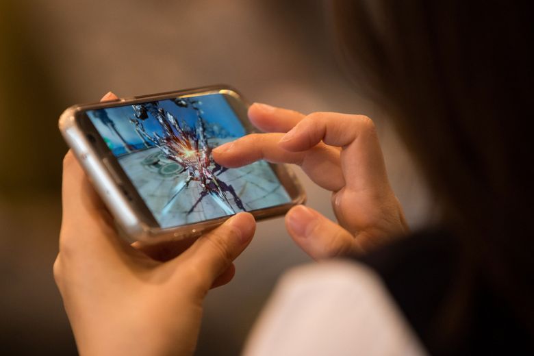 hand holding smartphone with epic games store logo on the screen