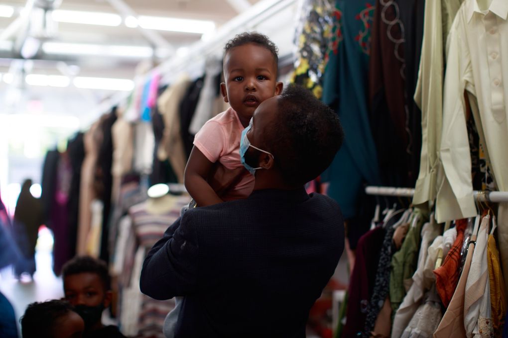 Faisal Mohamed, co-owner of the SeaTac International Mall, picks up his nephew Zuhaib, 2. 217135 (Erika Schultz / The Seattle Times)