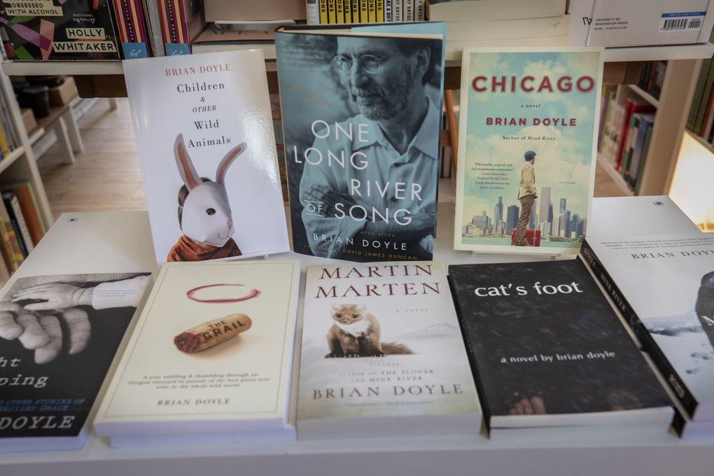 Beloved, bestselling local author Brian Doyle holds down a table at Three Trees Books in Burien. Doyle is the uncle of Tim Miller, who opened Three Trees with his wife Ingrid more than two years ago. (Ellen M. Banner / The Seattle Times)