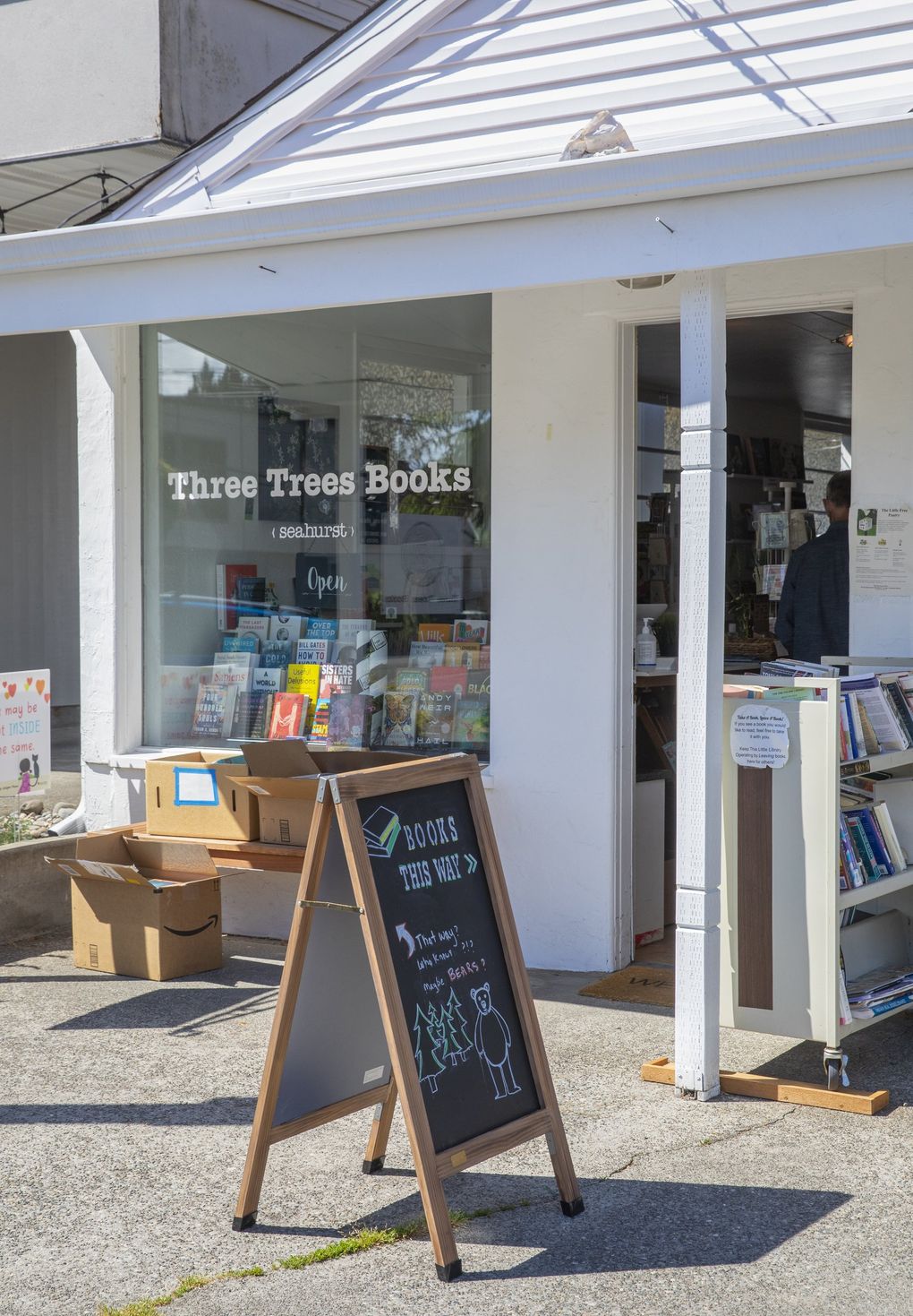At Three Trees Books indie bookstore in Burien, people drop off puzzles and books that are free for any passerby who wants them. (Ellen M. Banner / The Seattle Times)