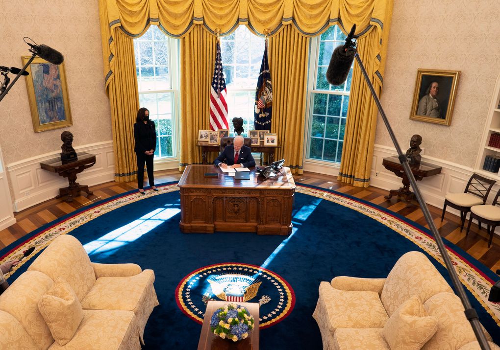 President Joe Biden signs executive actions in the Oval Office on Jan. 28, 2021, as Vice President Kamala Harris looks on. While aides say Biden is quick to demonstrate his displeasure, he is also prone to displays of unexpected warmth. (Doug Mills / The New York Times)
