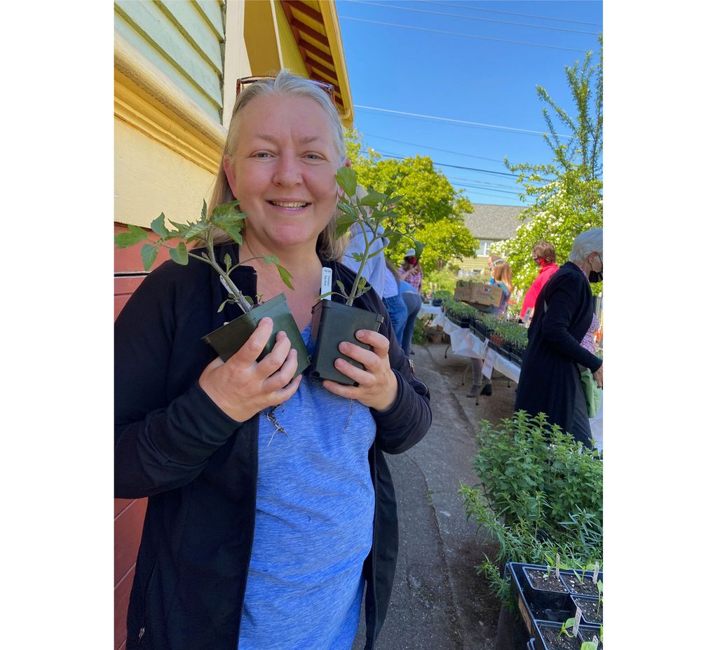 Jeanene Miller, owner of Abundant Greens Urban Farm and Nursery, poses with tomato starts at her Ballard location. (Courtesy of Karen G. Anderson)