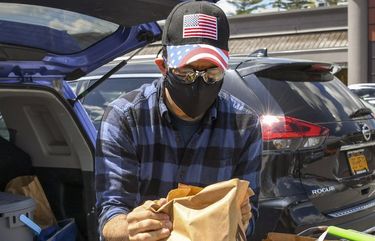 Joe Glickman loads groceries into his car in Slingerlands, N.Y., outside Albany, on May 13, 2021. Glickman has been wearing two masks and goggles for grocery runs — and says he plans to continue doing so for at least the next five years. (Cindy Schultz/The New York Times)