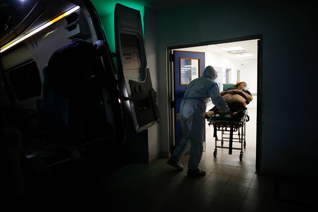 FILE – In this May 1, 2021 file photo, a healthcare worker pushes a woman who is suspected of having COVID-19 into Llavallol Dr. Norberto Raúl Piacentini Hospital in Lomas de Zamora, Argentina. The government of President Alberto Fernández on May 21 announced a strict lockdown for the first time this year after Argentina exceeded its daily record of virus infections and COVID-19 deaths. (AP Photo/Natacha Pisarenko, File)