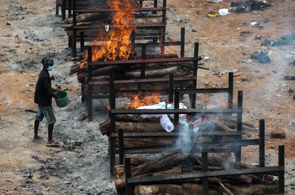 Bodies of people who died of COVID-19 are cremated at an open crematorium on the outskirts of Bengaluru, Karnataka state, India, Wednesday, May 12, 2021. (AP Photo/Aijaz Rahi)