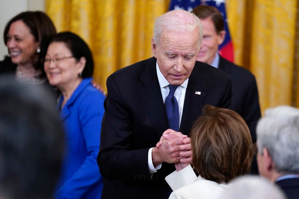 In this May 20, 2021, file photo President Joe Biden holds House Speaker Nancy Pelosi’s hand as they talk after signing the COVID-19 Hate Crimes Act, in the East Room of the White House in Washington. In the background Vice President Kamala Harris hugs Sen. Mazie Hirono, D-Hawaii. (AP Photo/Evan Vucci)