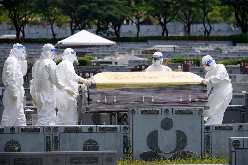 Health workers wearing Personal Protective Equipment (PPE) carry a coffin during a funeral for COVID-19 victim at Nirvana memorial, a Buddhist, Taoist and Christian cemetery in Semenyih, Malaysia, Wednesday, May 26, 2021. Malaysia’s latest coronavirus surge has been taking a turn for the worse as surging numbers and deaths have caused alarm among health officials, while cemeteries in the capital are dealing with an increasing number of deaths. (AP Photo/Vincent Thian)