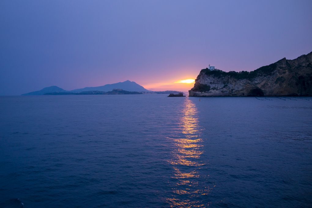 FILE – In this Oct. 1, 2016 file photo, sunset is over the Italian Islands of Procida and Ischia in the Bay of Naples, Italy. Italy on Friday will open a mass vaccination campaign on small, remote islands where numbers of residents and health care services are limited. The office of Italy’s virus czar said the campaign would initially target the Aeolian Islands north of Sicily and Isola Capraia off the Tuscan coast. Other remote areas on the mainland _ isolated villages in the Alps and Apennine mountains _ might be targeted with similar campaigns. (AP Photo/Alexander Zemlianichenko)