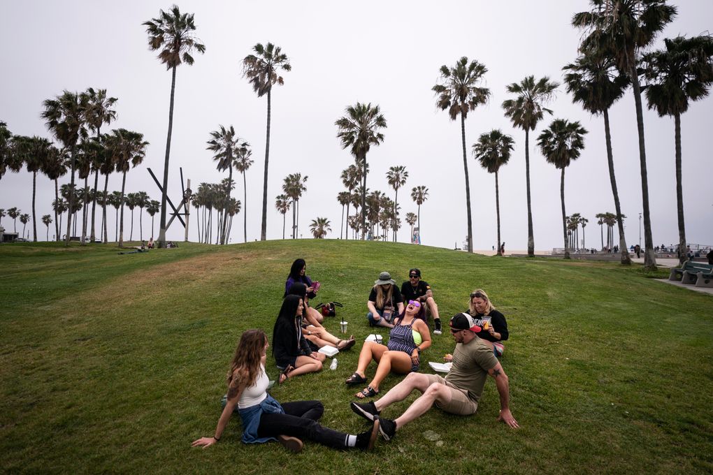 FILE – In this May 5, 2021, file photo, a group of friends, who said they are fully vaccinated for COVID-19, mingle on the beach in the Venice section of Los Angeles. COVID-19 deaths in the U.S. have tumbled to an average of just over 600 per day — the lowest level in 10 months — with the number of lives lost dropping to single digits in well over half the states and hitting zero on some days. (AP Photo/Jae C. Hong, File)