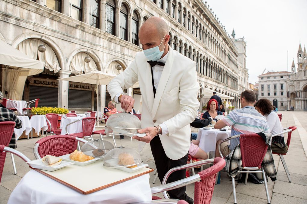 A waiter works in St. Mark’s Square in Venice, northern Italy, Saturday, May 1, 2021. Italy is gradually reopening after six months of rotating virus closures allowing outdoor dining. (Filippo Ciappi/LaPresse via AP)