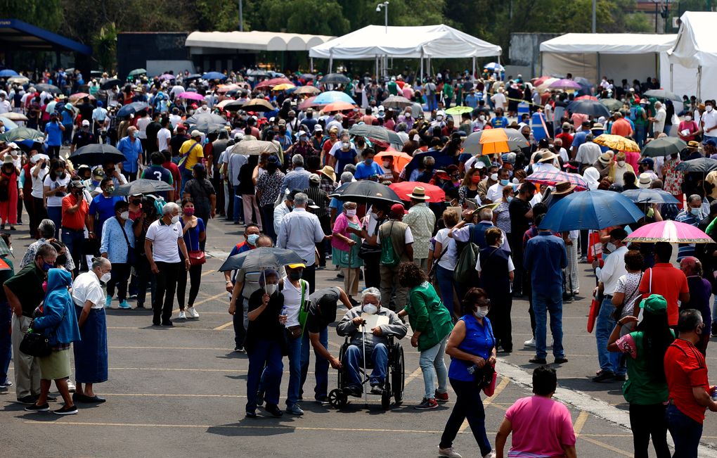 FILE – In this April 12, 2021 file photo, people over age 60 line up to be vaccinated with the AstraZeneca COVID-19 vaccine at the University Olympic Stadium in Mexico City. Mexico City’s government announced on Friday, May 7, 2021 that public hospitals dedicated to fighting COVID-19 are experiencing their lowest rate occupancy of the pandemic and the city is slightly easing some restrictions, more than three months after infections peaked in the Mexican capital in January. (AP Photo/Marco Ugarte, File)