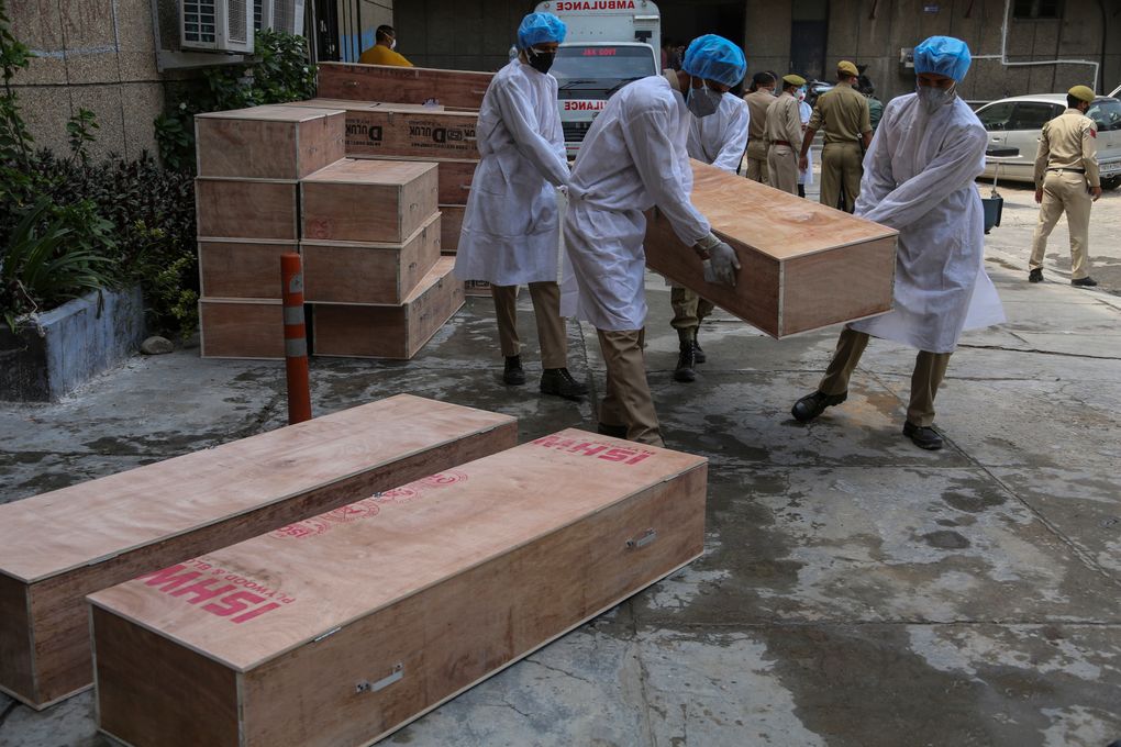 Jammu and Kashmir State Disaster Response Force soldiers carry empty coffins for transporting bodies of people who died of COVID-19 outside government medical hospital in Jammu, India, Wednesday, May 19, 2021. (AP Photo/Channi Anand)