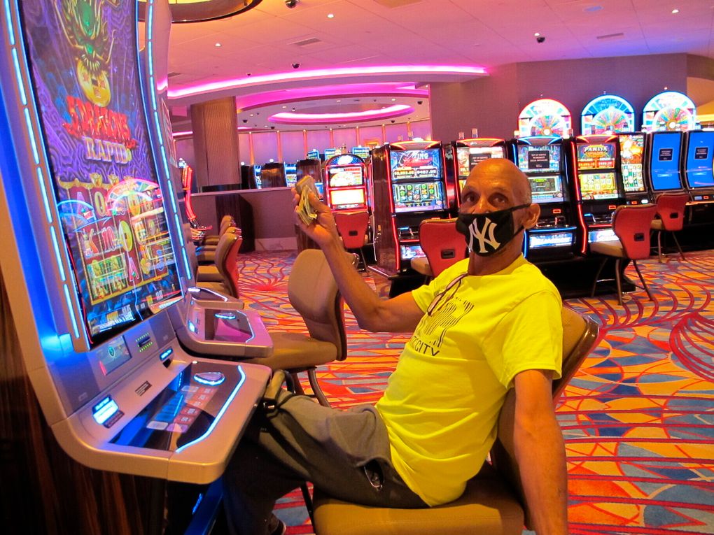 FILE- In this July 2, 2020 file photo, Gary Royster of Atlantic City holds up a wad of cash he used to gamble at the Hard Rock casino in Atlantic City on the day the casino reopened after being shut down for months amid the coronavirus outbreak. On May 3, 2021, Hard Rock officials told The Associated Press they will spend $20 million on renovations, the latest in a line of Atlantic City casinos to reinvest during the coronavirus pandemic. (AP Photo/Wayne Parry, FILE)