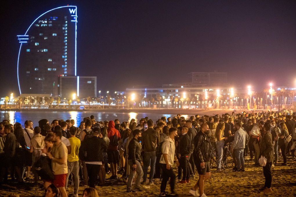 People crowded on the beach in Barcelona, Spain, Sunday, May 9, 2021. Barcelona residents were euphoric as the clock stroke midnight, ending a six-month-long national state of emergency and consequently, the local curfew. Spain is relaxing overall measures to contain the coronavirus this weekend, allowing residents to travel across regions, but some regional chiefs are complaining that a patchwork of approaches will replace the six-month-long national state of emergency that ends at midnight on Saturday. (AP Photo/Emilio Morenatti)