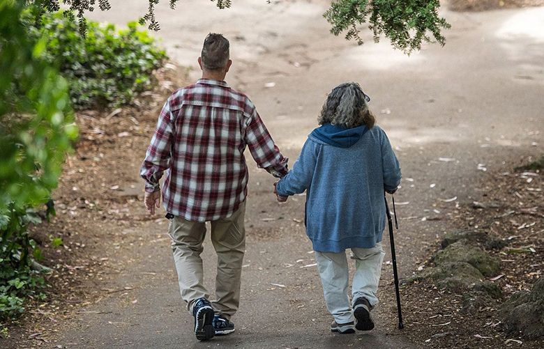 n elderly couple holds hands while walking on a path at Golden Gate Park in San Francisco on June 21, 2018. (David Paul Morris / Bloomberg)