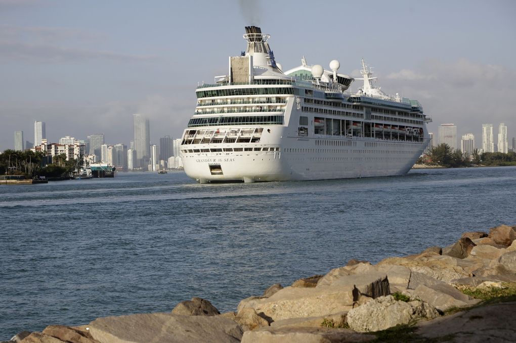 Royal Caribbean said it will recommend passengers get the COVID-19 vaccine, but not require it, on its cruises this season, with the exception of cruises from Seattle and the Bahamas. The reversal is an apparent submission to Florida Gov. Ron DeSantis. Above, Royal Caribbean’s Grandeur of the Seas comes into the Port of Miami in Miami Beach, Fla., in 2018. (Lynne Sladky / The Associated Press)