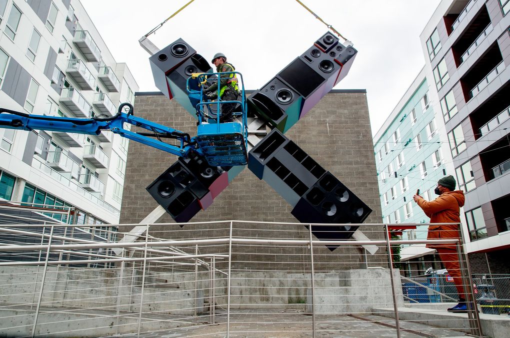 Artist Christopher Paul Jordan, right, films his sculpture “andimgonnamisseverybody” during its installation at the AIDS Memorial Pathway on Capitol Hill in Seattle on May 24, 2021. (Erika Schultz / The Seattle Times)