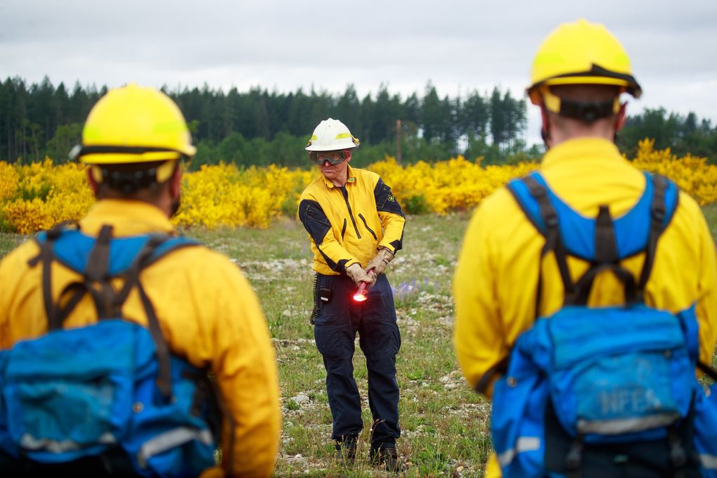 Jordan Simmonds, a captain with Eastside Fire and Rescue, leads a firing devices workshop during a DNR wildfire training at Joint Base Lewis-McChord last month. (Erika Schultz / The Seattle Times)