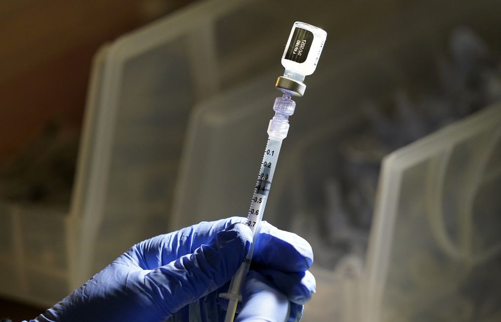 A Pfizer vaccine is prepared at a COVID-19 vaccination clinic at PeaceHealth St. Joseph Medical Center in June. (AP Photo/Elaine Thompson)