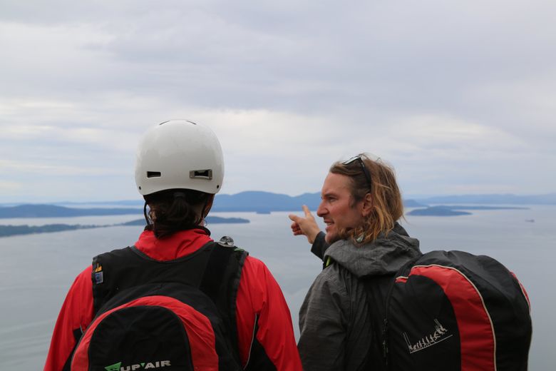 Paragliding pilot and instructor Peter Stark points to the island toward which Stephen S. Howie is supposed to run during their tandem launch at Samish Overlook, south of Bellingham. Stark’s instructions to Howie were to keep running, even after his feet were off the ground. He’d let him know when to stop. (Maria McLeod)