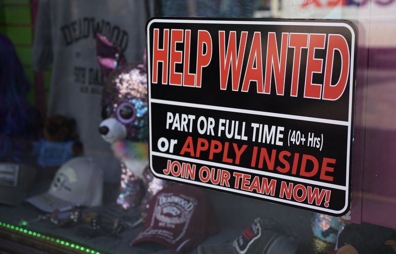 In this May 26, 2021 photo, a sign for workers hangs in the window of a shop along Main Street in Deadwood, S.D.   (AP Photo/David Zalubowski) 