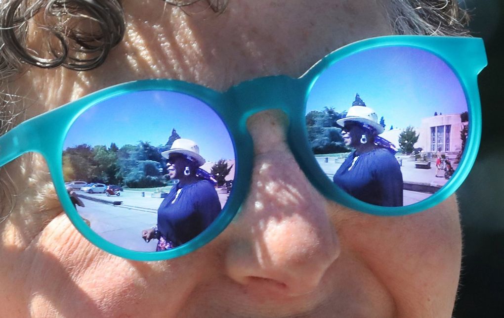Vivian Phillips is reflected in podcast partner Marcie Sillman’s sunglasses at Volunteer Park on Capitol Hill. The two have teamed up to create an arts and culture podcast called “DoubleXposure.” (Alan Berner / The Seattle Times)