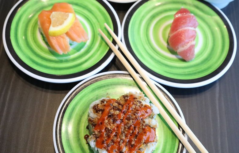 The new Sushi Bar in Bellevue is Kura Revolving Sushi Bar.
Some of the selections for you to choose include the Golden Crunchy roll, center, foreground. At left is their Dashi Olive Salmon, and at right is their Blue Fin Toro.. 217467
